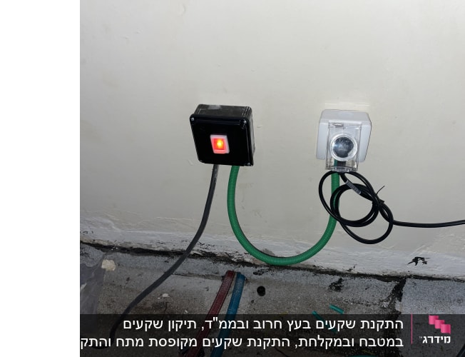 שקע חשמלי עם כבל ירוק ומתג מואר